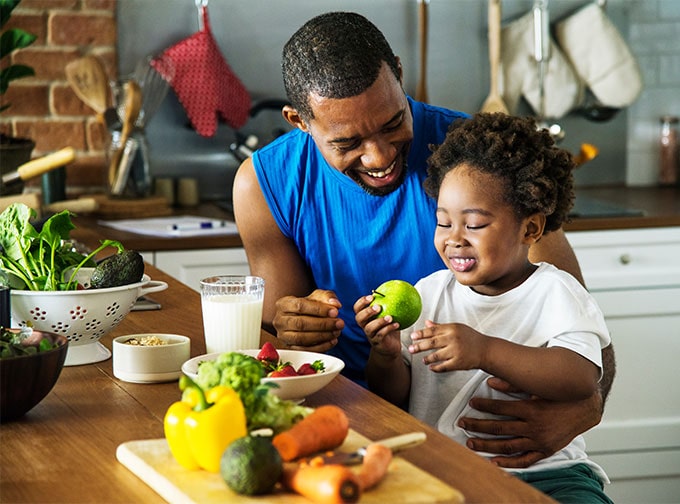 young healthy adult preparing food with daughter